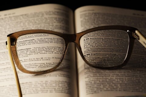 Eine Brille liegt auf einem Buch.