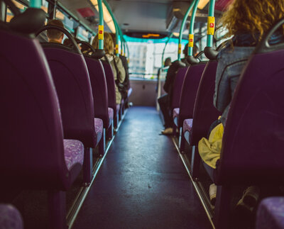 Ansicht von hinten auf mehrere Personen in einem Bus