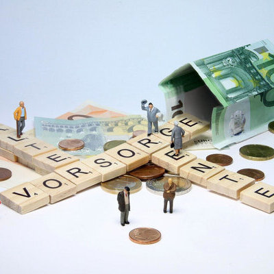 Per Scrabble gelegte Wörter Alter, Vorsorge, Rente und Ein Haus aus Geldscheinen.