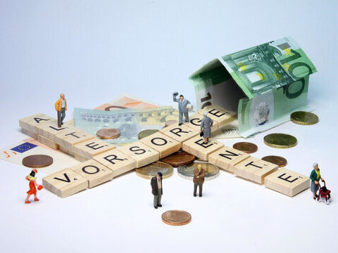 Per Scrabble gelegte Wörter Alter, Vorsorge, Rente und Ein Haus aus Geldscheinen.